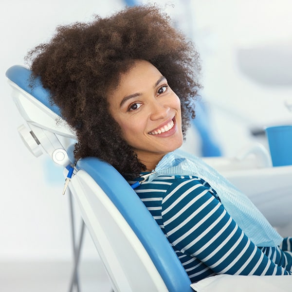 A young woman in the dentist's chair smiling